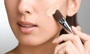 Bottle of liquid foundation with its applicator, highlighting the product's packaging and branding.