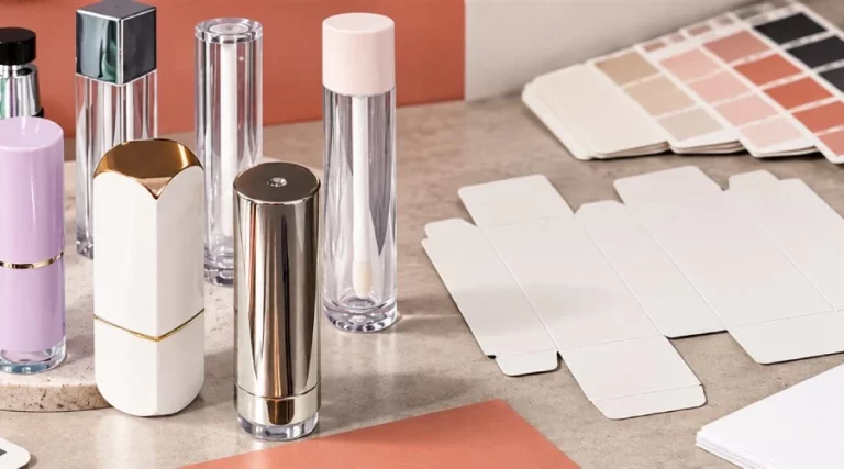 White-label cosmetic tubes and cartons beside blank dielines, color chips, and packaging proof materials